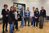 Die Teilnehmerinnen des Workshops stehen vor einer Pinnwand und schauen in die Kamera. 