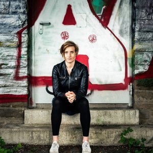 Kathrin Längert sitzt vor einer Wand