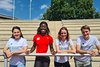 Die Sprinterin Yasmin Kwadwo-Bühner steht mit dem Projektteam von Klischeefrei im Sport vor einer leeren Tribüne.