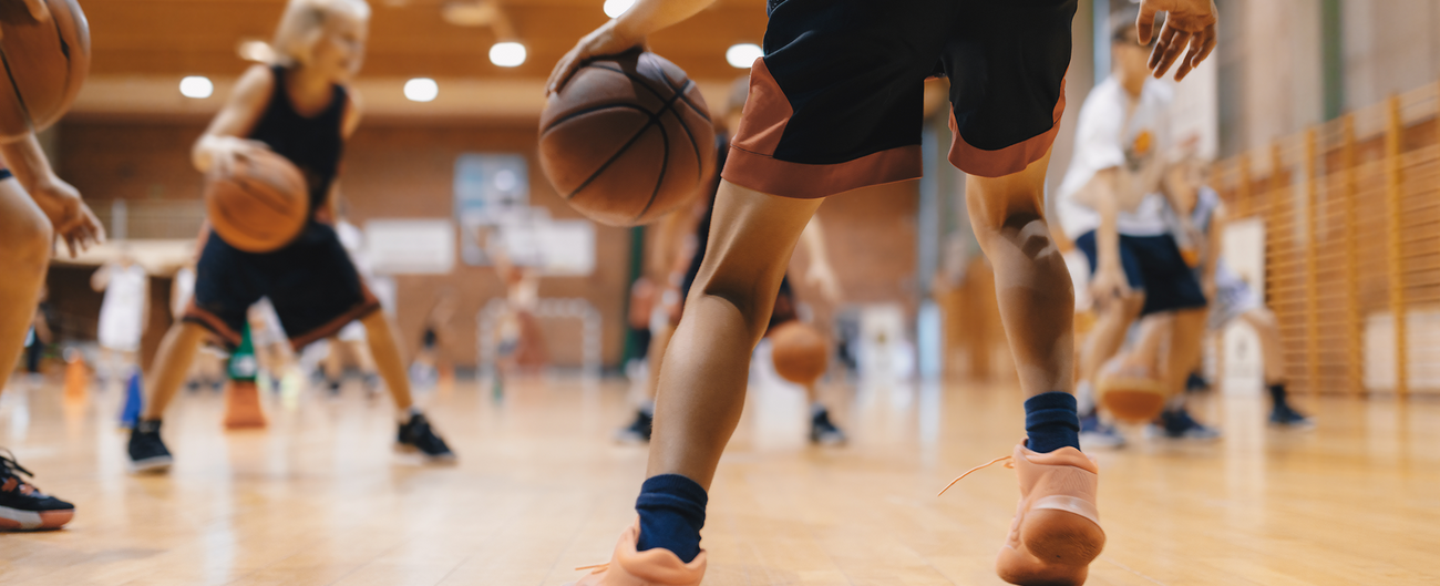 Kinder spielen Basketball in einer Halle