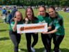 Drei Spielerinnen halten das orangene #nostereotypes-Banner