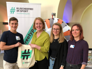 Lisa Paus mit KiS-Team vor einem Stand